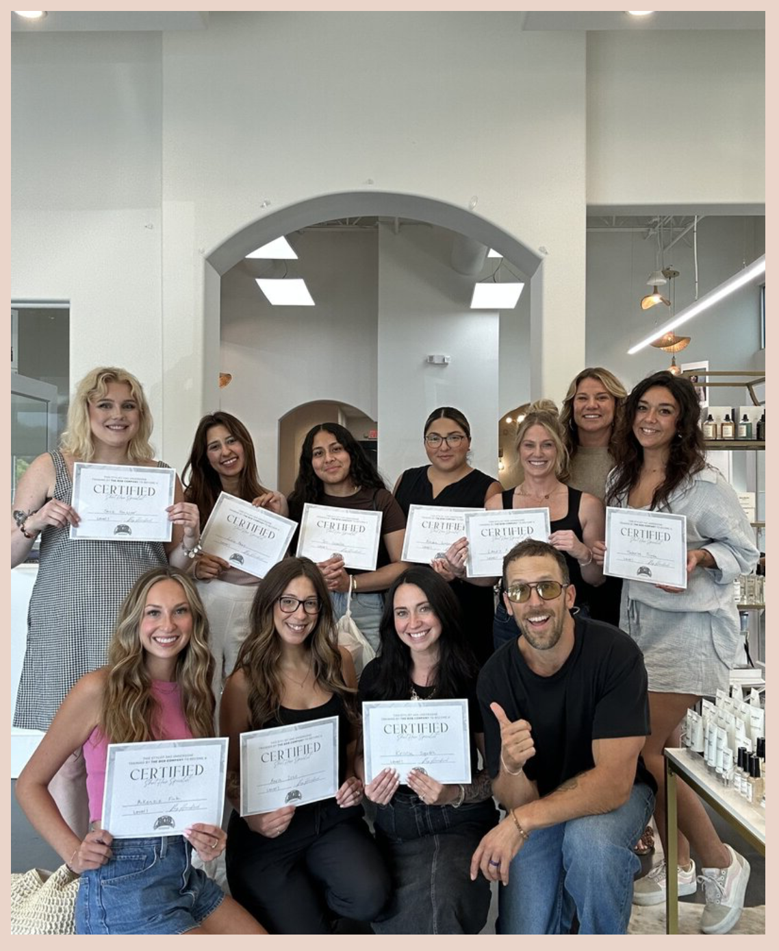 A smiling salon team holds Bob Company certificates after a certification event