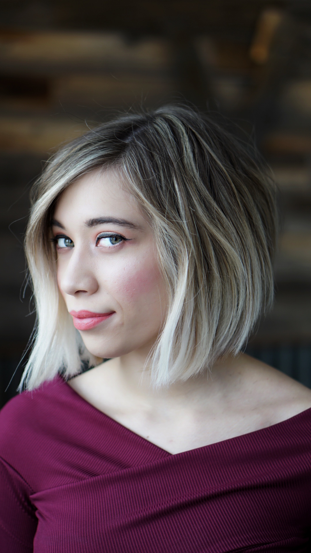 Angled bob with blonde face-framing highlights and a darker root
